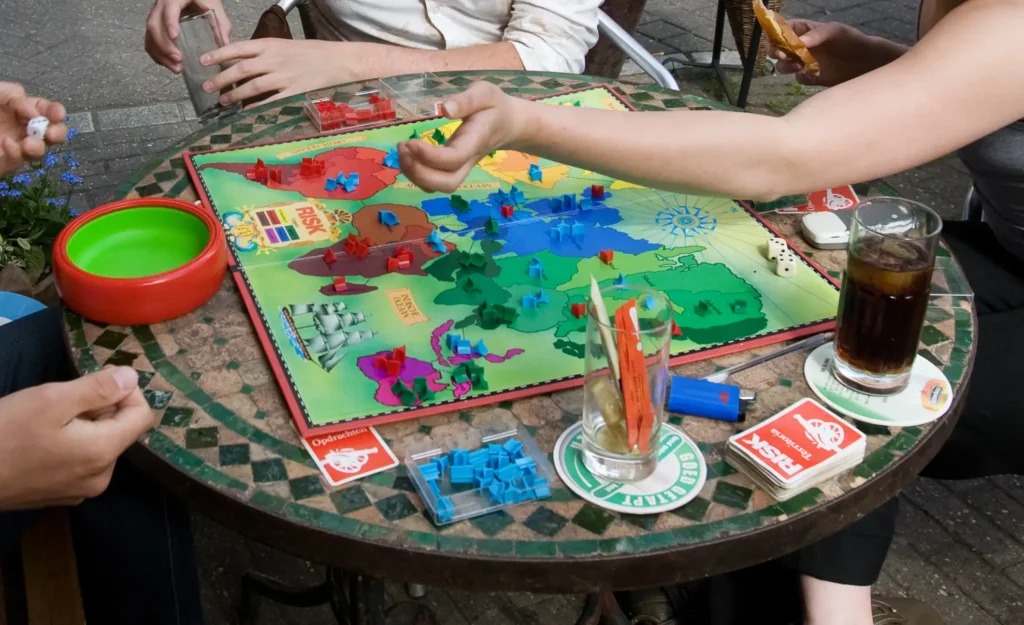Photo of Young group playing RISK in a street cafe. Amsterdam, The Netherlands.